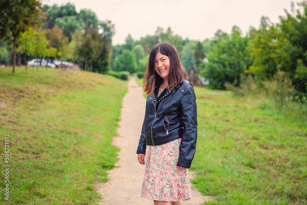 smiling young woman standing on the path in the park smiling young woman standing on the path in the park