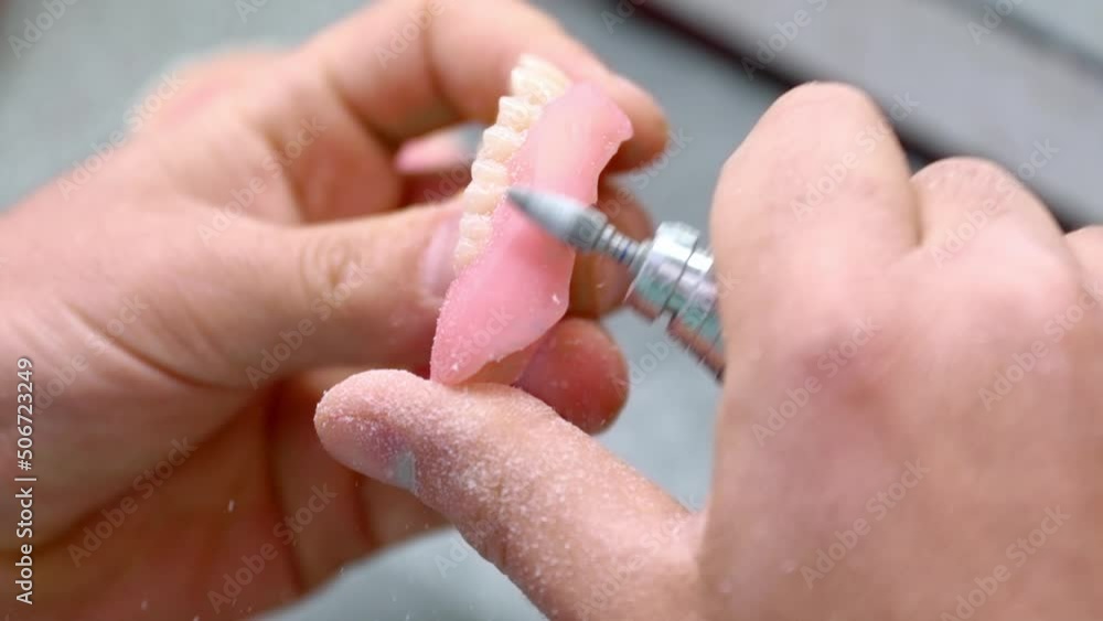 dental technician works in his workshop and makes artificial teeth for dentistry. in the frame are the hands of the master and the teeth created by the specialist. Slow motion dental technician works in his workshop and makes artificial teeth for dentistry. in the frame are the hands of the master and the teeth created by the specialist. Slow motion
