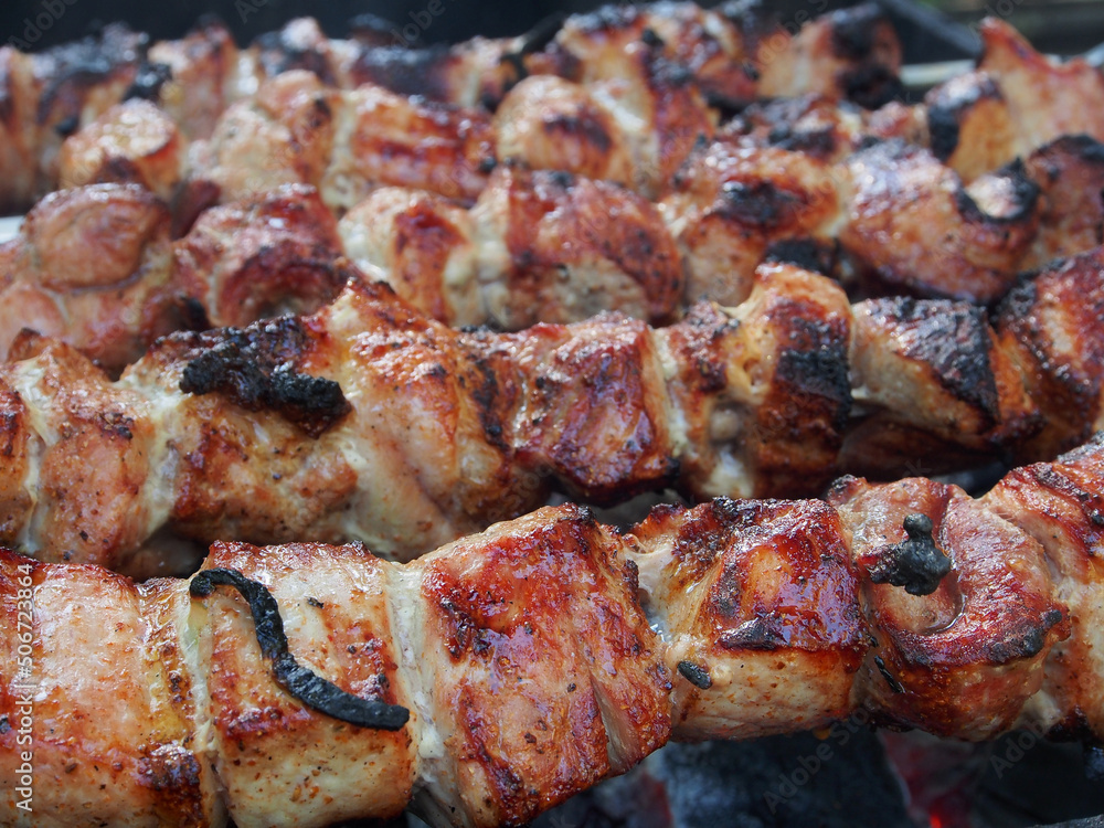 Picnic, shashlik on skewers is prepared on the grill over the coals, cooking natural food.