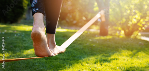 person walking on a slackline barefoot. strength and balance exercises photo