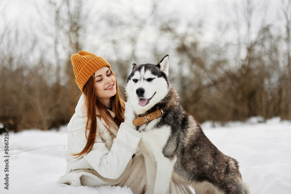 cheerful woman outdoors in a field in winter walking with a dog winter holidays cheerful woman outdoors in a field in winter walking with a dog winter holidays