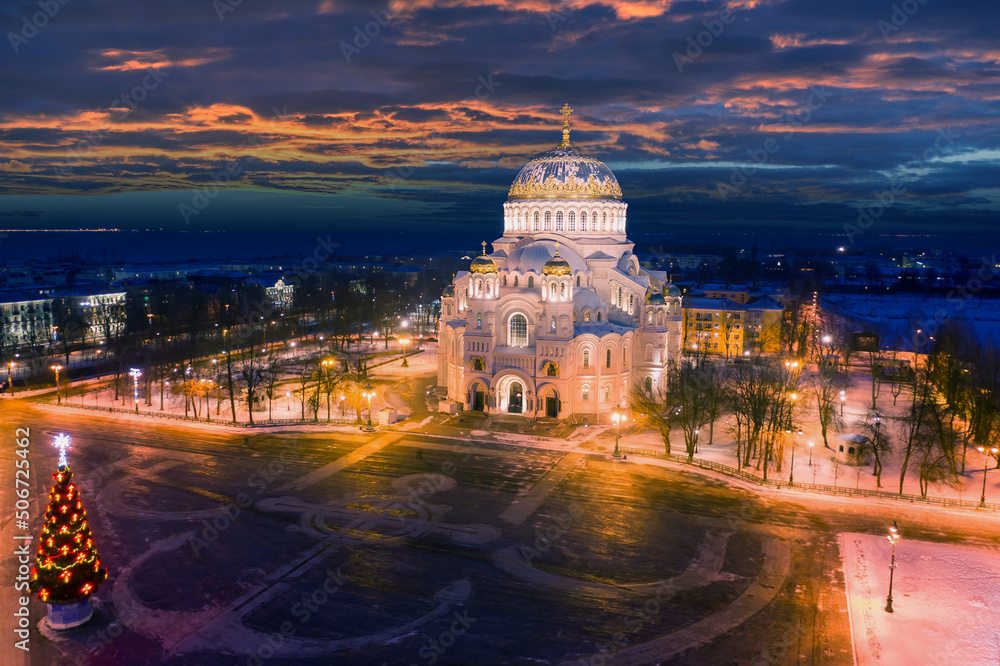 Fototapeta premium Saint-Petersburg, Kronstadt. Christmas in Russia. Christmas evening in Kronstadt. Christmas tree at the St. Nicholas Naval Cathedral in Kronstadt. New Year in Russia. Aerial view of the festive city.