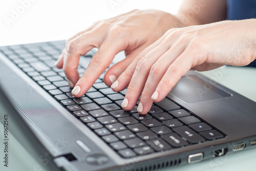 Woman uses a laptop and typ...