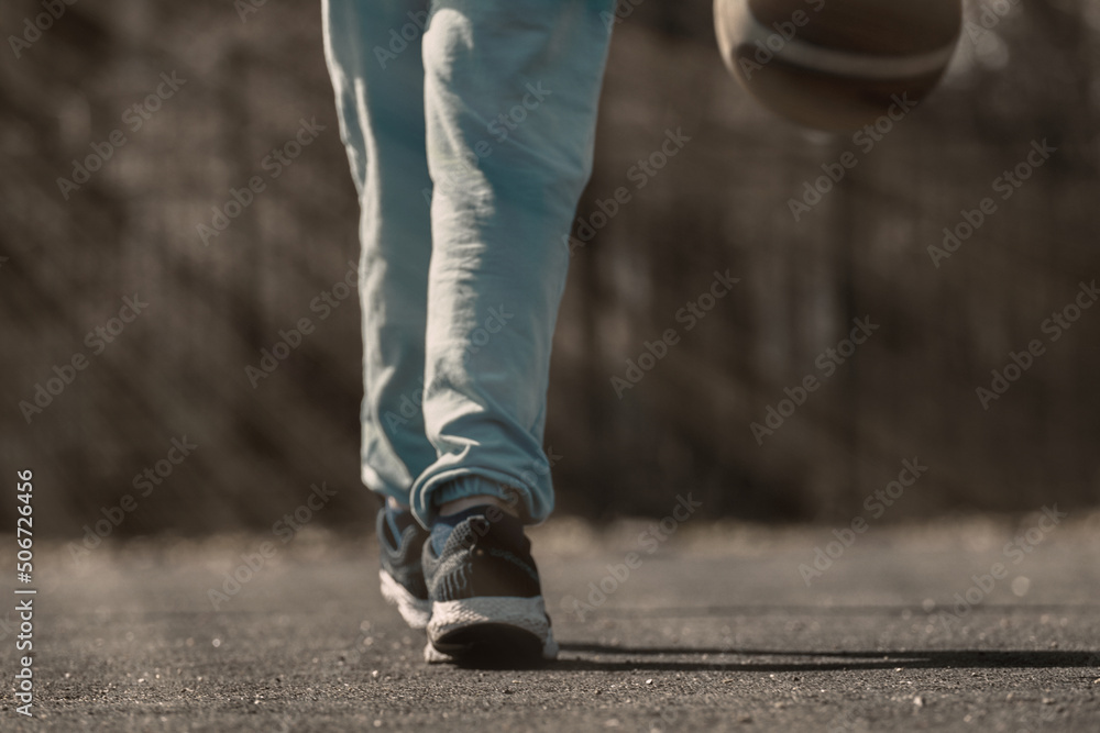 Child's feet on the sports ground, close-up, blur. Basketball court outdoor.