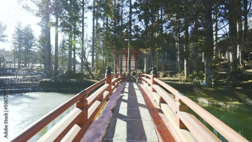Cinematic gimbal shot of historic bridge over pond at Buddhist temple in Mount Koya in Wakayama prefecture, Japan