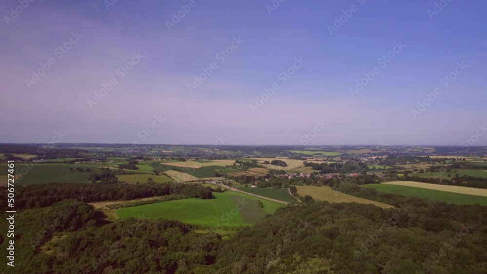 Aerial Landscape: Drone descends towards the road with traffic, view of the countryside, green farmlands and forests with blue purple sky. South Limburg the Netherlands Aerial Landscape: Drone descends towards the road with traffic, view of the countryside, green farmlands and forests with blue purple sky. South Limburg the Netherlands