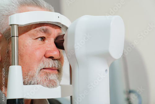 examination of elderly man on corneo topographer.modern clinic photo