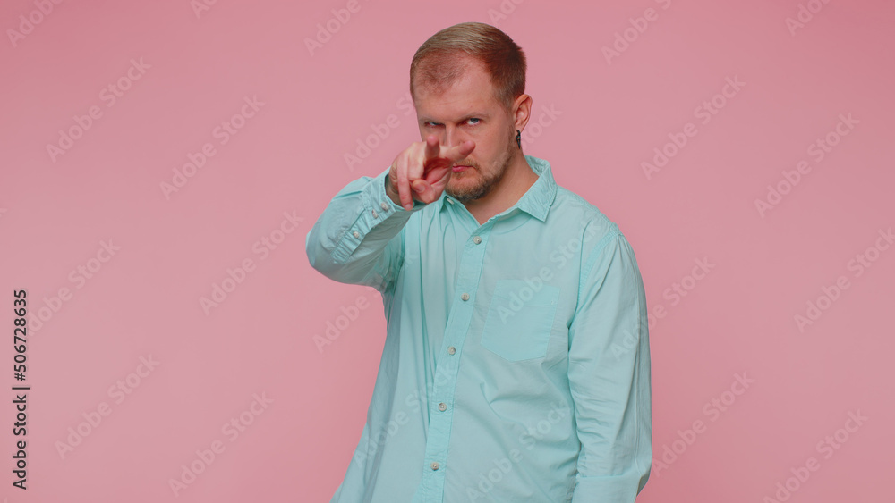 I am watching you. Man in blue casual shirt pointing at his eyes and camera, show I am watching you gesture, spying on someone. Young adult blonde guy boy isolated alone on pink studio wall background I am watching you. Man in blue casual shirt pointing at his eyes and camera, show I am watching you gesture, spying on someone. Young adult blonde guy boy isolated alone on pink studio wall background