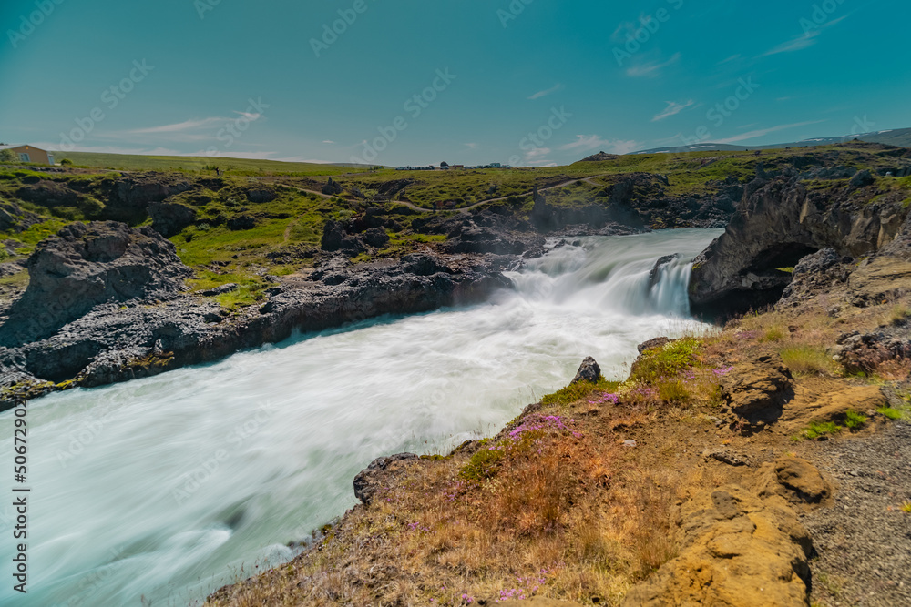 Long exposure photo of magnificent Godafoss waterfall in northern Iceland on a warm summer day. Visible frog from drops of water coming from the waterfall.