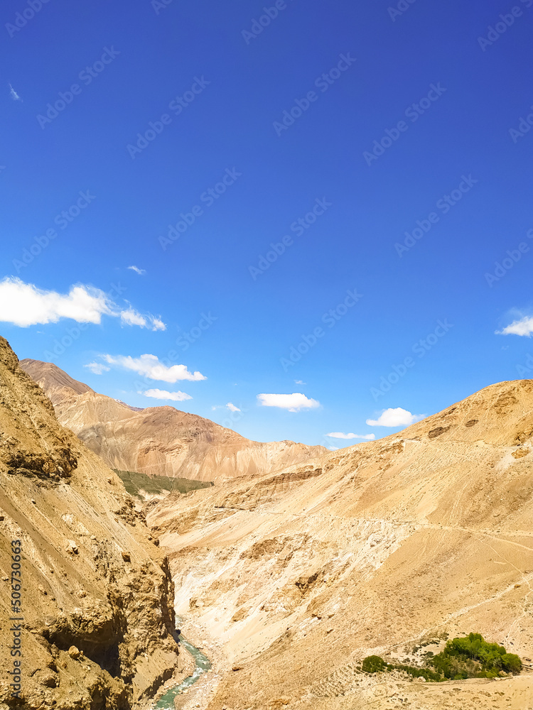 A river flowing in the middle of the  valley with blue sky and clouds