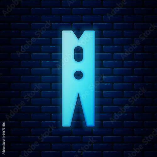 Glowing neon Old wood clothes pin icon isolated on brick wall background. Clothes peg. Vector