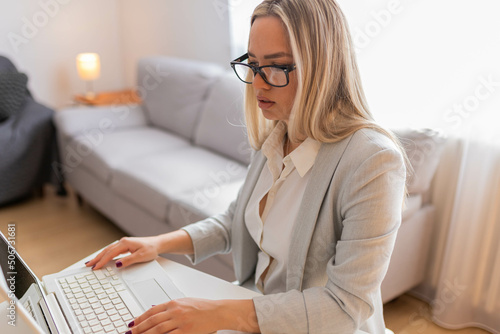 Young woman working at her home. Woman working at lap top. Happy business woman working at the desk.