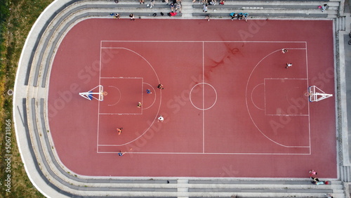 Aerial view of the orange basketball court located in a beautiful green park not far from the city center
