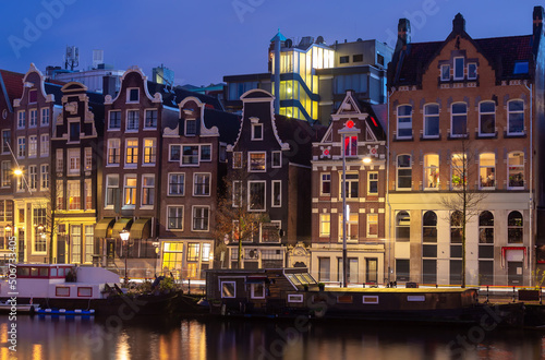 Beautiful old houses on the city waterfront of Amsterdam at sunset.