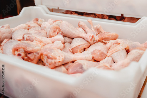 Containers on a conveyor line with raw chicken drumstick.Factory for the production of food from meat,poultry.Conveyor Belt Food.The meat factory.Automated production line in modern food factory.