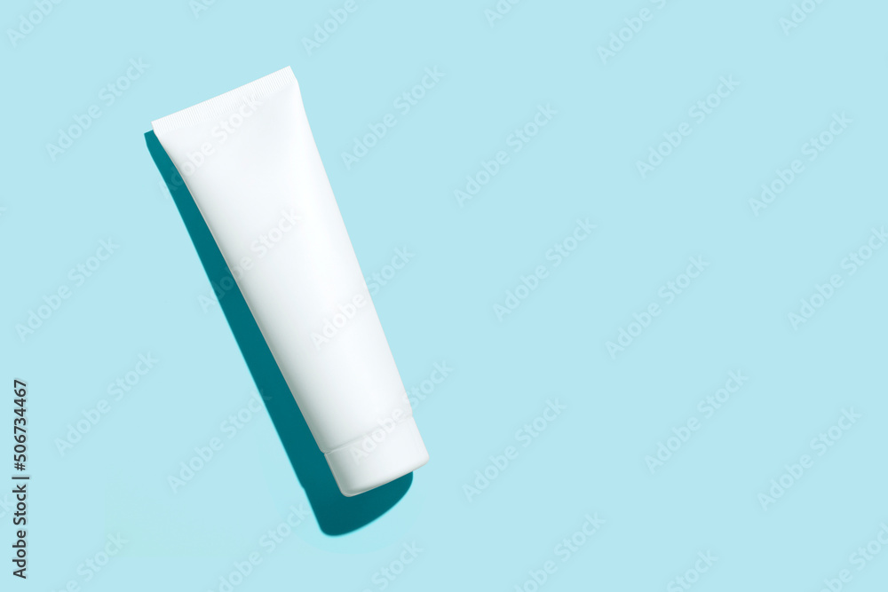 Blank white cosmetic tube isolated on blue background. Mock up. Blank white cosmetic tube isolated on blue background. Mock up.