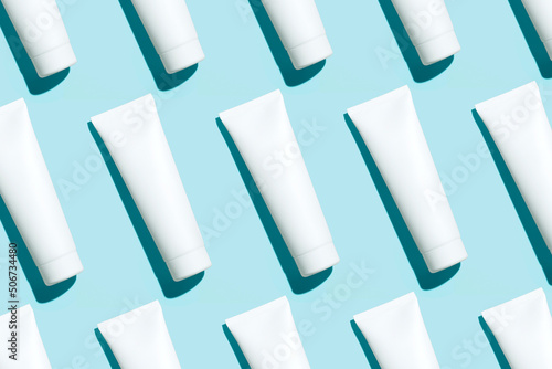 Pattern from mock up cosmetic or toothpaste tubes on blue background photo