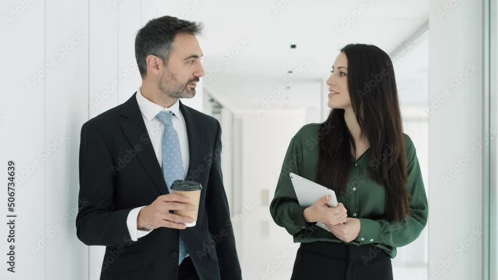 Video of two attractive business people working with digital tablet while talking and walking in a modern startup. Video of two attractive business people working with digital tablet while talking and walking in a modern startup.