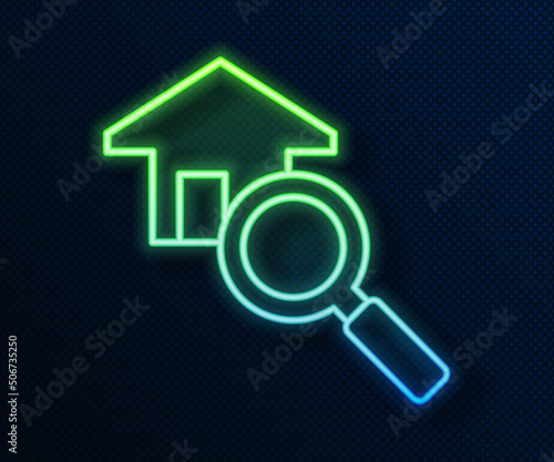Glowing neon line Search house icon isolated on blue background. Real estate symbol of a house under magnifying glass. Vector