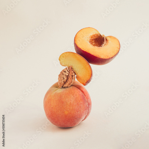 Balanced peaches levitate on the light nude background—still life minimal fruit composition. 