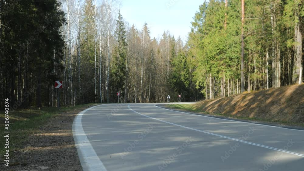 a cyclist rides on a beautiful European winding road on a sunny day a cyclist rides on a beautiful European winding road on a sunny day