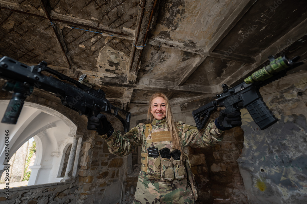 Caucasian woman in army uniform holding two machine guns. Caucasian woman in army uniform holding two machine guns.
