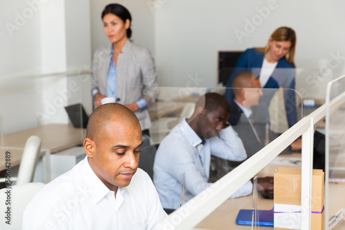 Successful manager works for laptops in company office