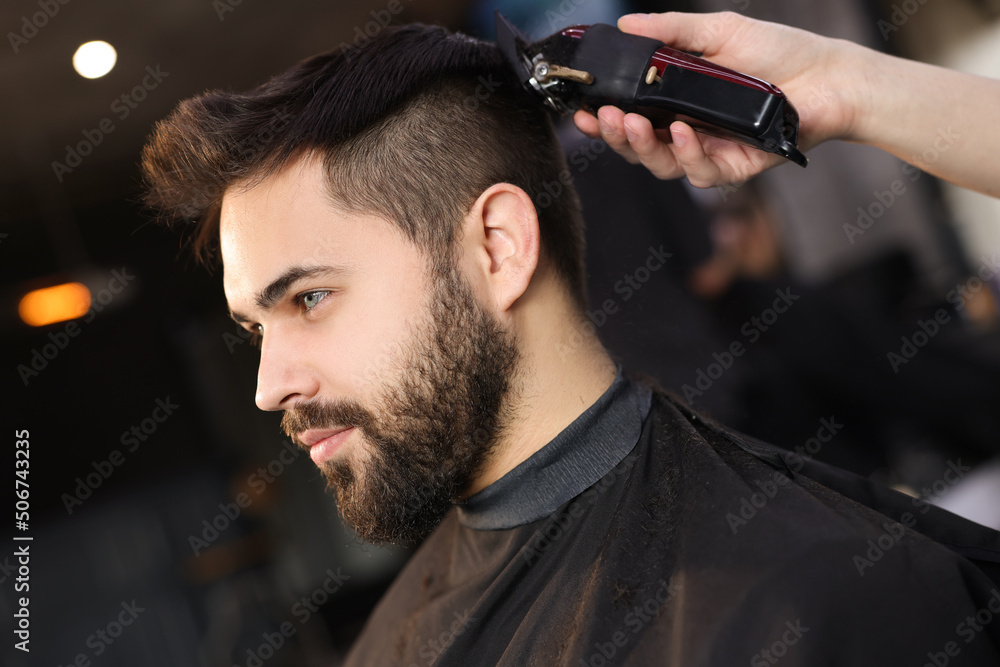 Professional hairdresser working with client in barbershop - obrazy, fototapety, plakaty 