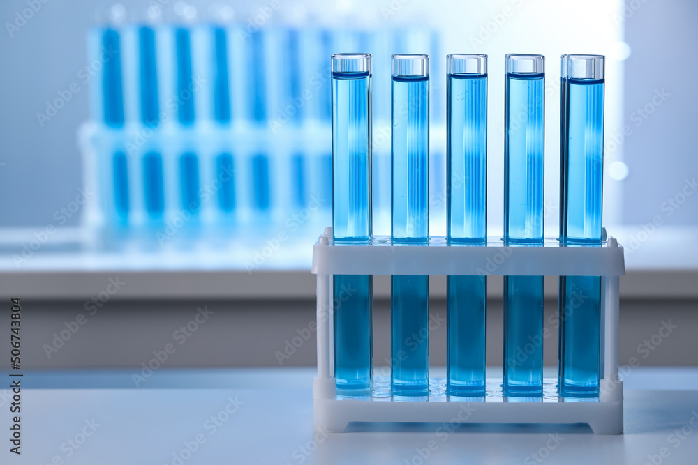 Test tubes with reagents on table in laboratory, space for text Test tubes with reagents on table in laboratory, space for text