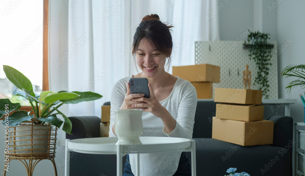 Smiling asian woman online seller using smart phone taking a photo of product for post to sell online on internet. Smiling asian woman online seller using smart phone taking a photo of product for post to sell online on internet.