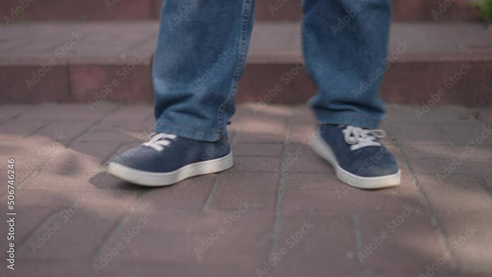 Close-up legs of confident joyful little person dancing in slow motion outdoors. Happy unrecognizable young woman with dwarfism enjoying hobby on sunny day in city Close-up legs of confident joyful little person dancing in slow motion outdoors. Happy unrecognizable young woman with dwarfism enjoying hobby on sunny day in city