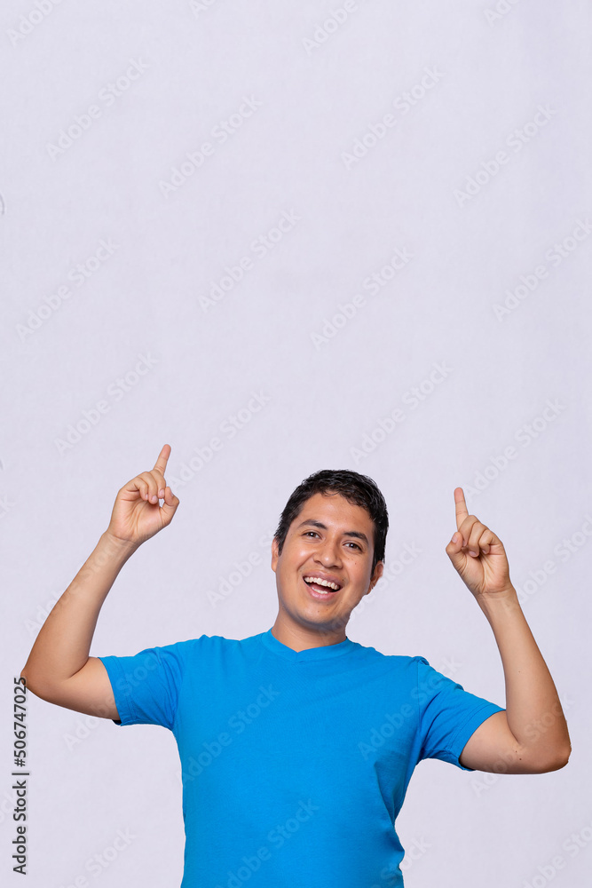 young latino man pointing up at something blue shirt white background vertical young latino man pointing up at something blue shirt white background vertical