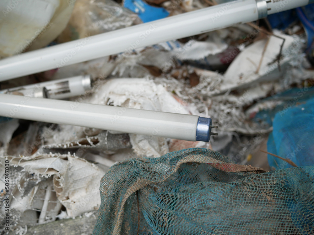 Obraz premium wasted fluorescent light tube thrown in the garbage pile.