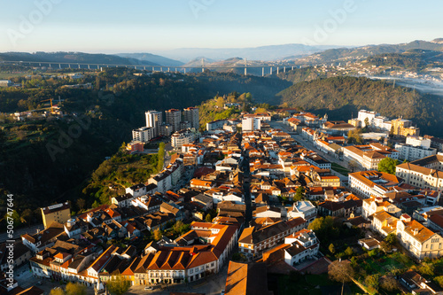 Picturesque drone view of Vila Real cityscape in valley framed by Alvao and Marao mountain ranges in light fog with suspension viaduct crossing Corgo River in background on sunny spring day, Portugal photo