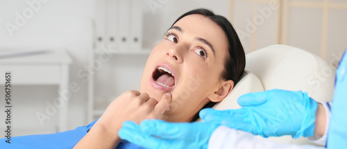 Beautiful woman with dental braces visiting dentist in clinic photo