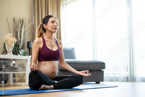 Asian young beautiful pregnant girl doing yoga pilates workout at home