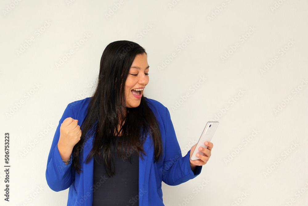 Latin adult woman with straight black hair and a blue jacket sends and receives messages from her cell phone very excited and happy makes purchases online in app
Latin adult woman with straight black hair and a blue jacket sends and receives messages from her cell phone very excited and happy makes purchases online in app