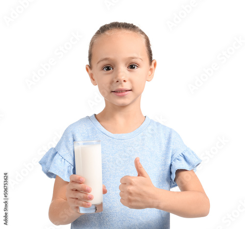 Little girl holding glass of milk and showing thumb up on white background