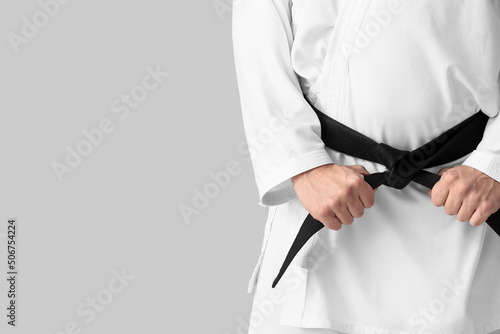 Принти на полотні Man in karategi and with black belt on light background, closeup