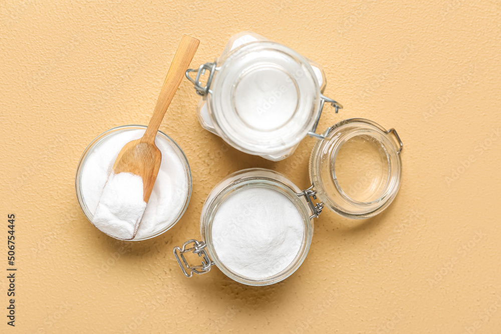 Jars and bowl with baking soda on beige background Jars and bowl with baking soda on beige background