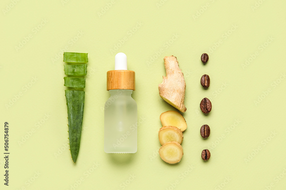 Bottle of natural serum with aloe leaf, ginger and coffee beans on green background Bottle of natural serum with aloe leaf, ginger and coffee beans on green background