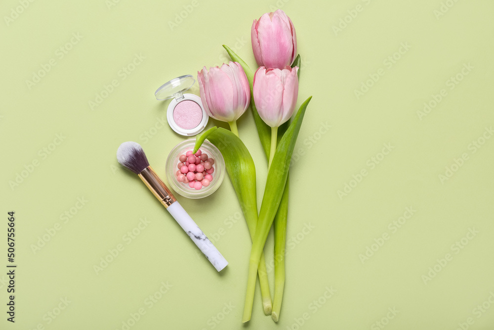Makeup brush with cosmetics and tulips on green background. Mother's Day celebration Makeup brush with cosmetics and tulips on green background. Mother's Day celebration