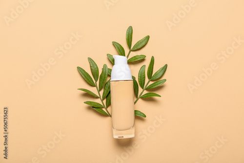 Makeup foundation with plant branches on beige background. Mother's Day celebration
