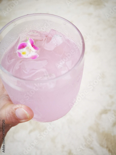 close up of a hand holding a glass of juice