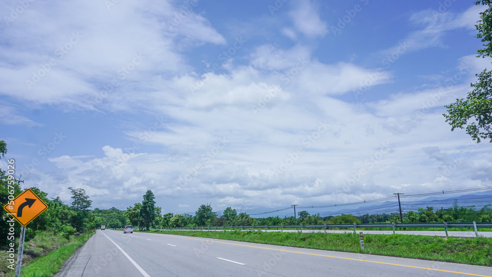 Blue sky lanscape with white clouds on a road signposted for tourism.