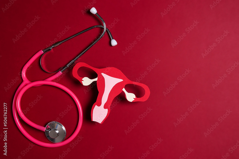 Women's health awareness concept. Uterus symbol with stethoscope on red background. Diagnostic and research women's reproductive system. - obrazy, fototapety, plakaty 