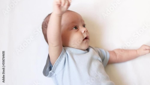 Video portrait of a baby toddler on a white background . Happy baby. A happy child. An infant looks into the camera . White background. High quality FullHD footage