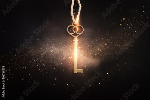 Golden key with glowing lights and dark background, wisdom, wealth, and spiritual concept photo