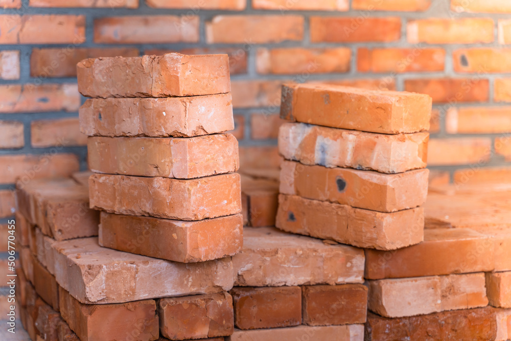 Fototapeta premium Red ceramic bricks stacked close up at a construction site. building materials