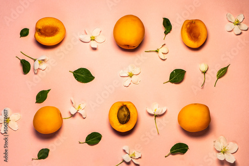 Delicious ripe sweet apricots on a pink background  smooth. selective focus. Apricots and sliced ones at the pastel pink background